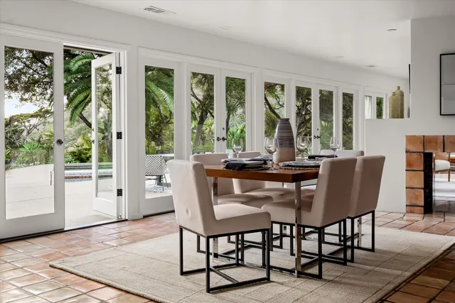 a view of a dining room with furniture large windows and wooden floor