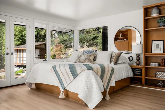 a bedroom with a bed wooden floor and window