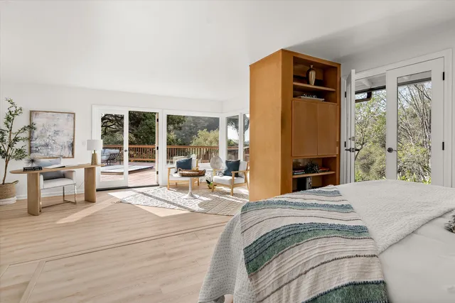 a spacious bedroom with a bed a table and large window