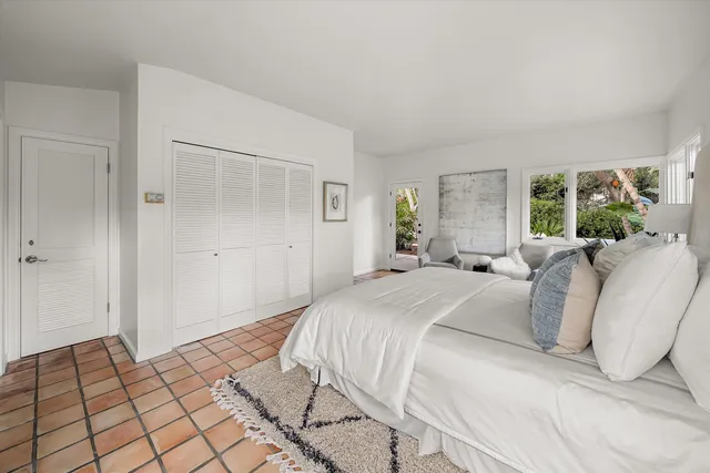 a spacious bedroom with a bed and a large window