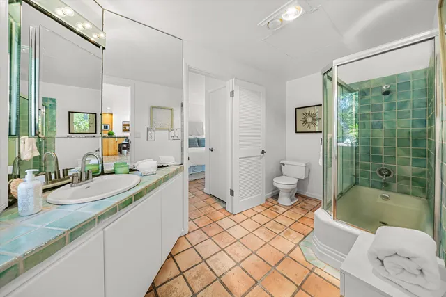 a spacious bathroom with a double vanity sink toilet mirror and shower