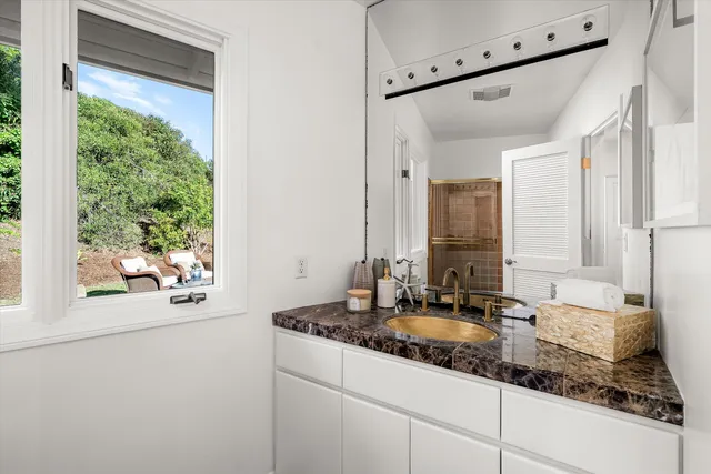 a bathroom with a granite countertop sink and a mirror