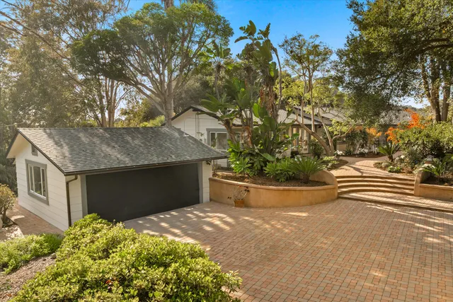 a view of a house with a yard and potted plants