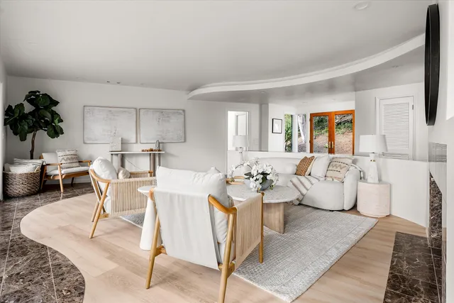 a living room with furniture a rug and white walls