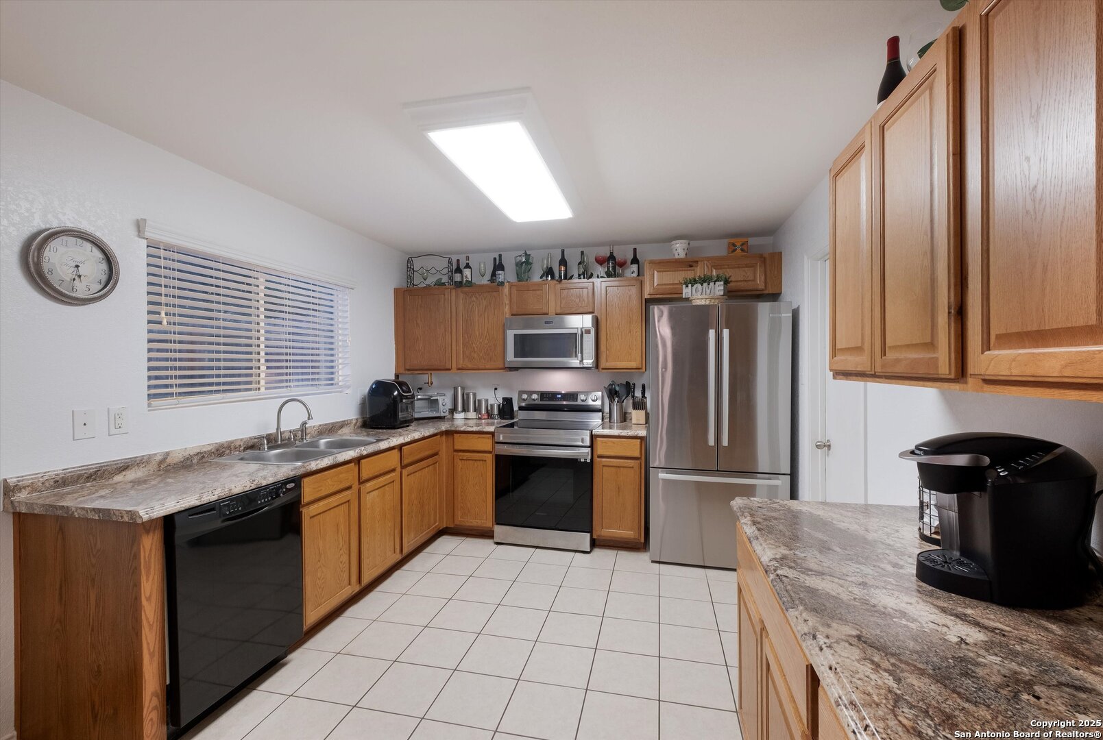 10711 Rindle Ranch San Antonio, TX 78249 - Photo 12 of 31 a kitchen with granite countertop stainless steel appliances a sink dishwasher a refrigerator oven and a stove next to a window