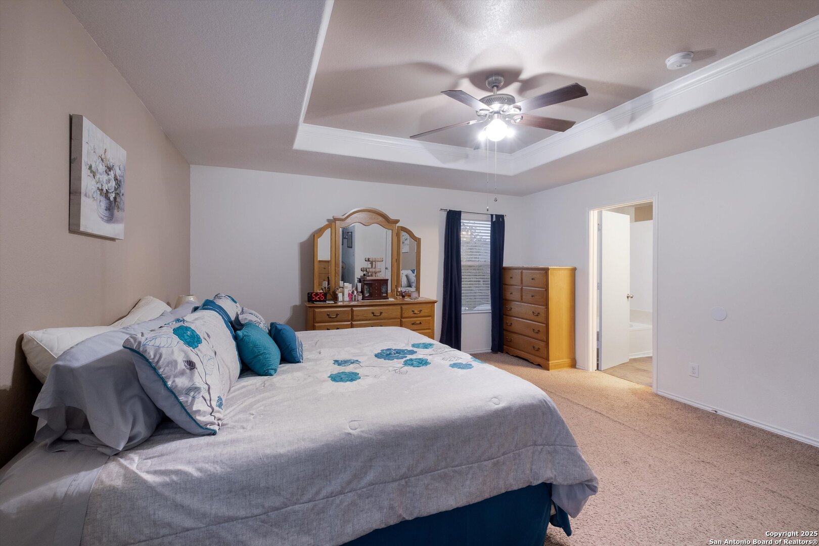 10711 Rindle Ranch San Antonio, TX 78249 - Photo 14 of 31 a bedroom with a large bed and a chandelier