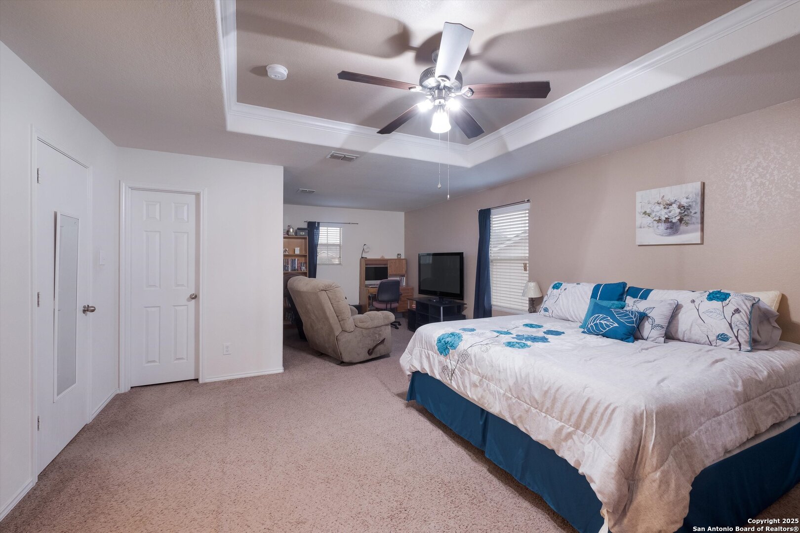 10711 Rindle Ranch San Antonio, TX 78249 - Photo 16 of 31 a spacious bedroom with a bed a couch and a chandelier