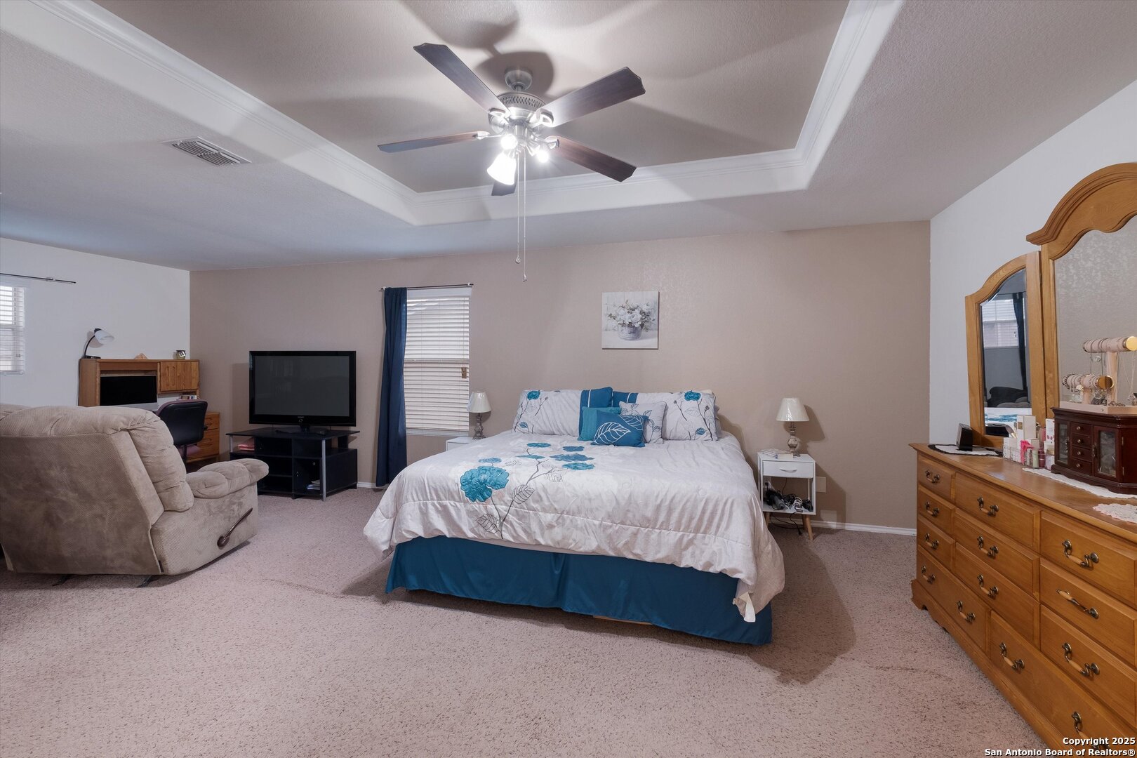 10711 Rindle Ranch San Antonio, TX 78249 - Photo 17 of 31 a spacious bedroom with a bed a couch and a chandelier