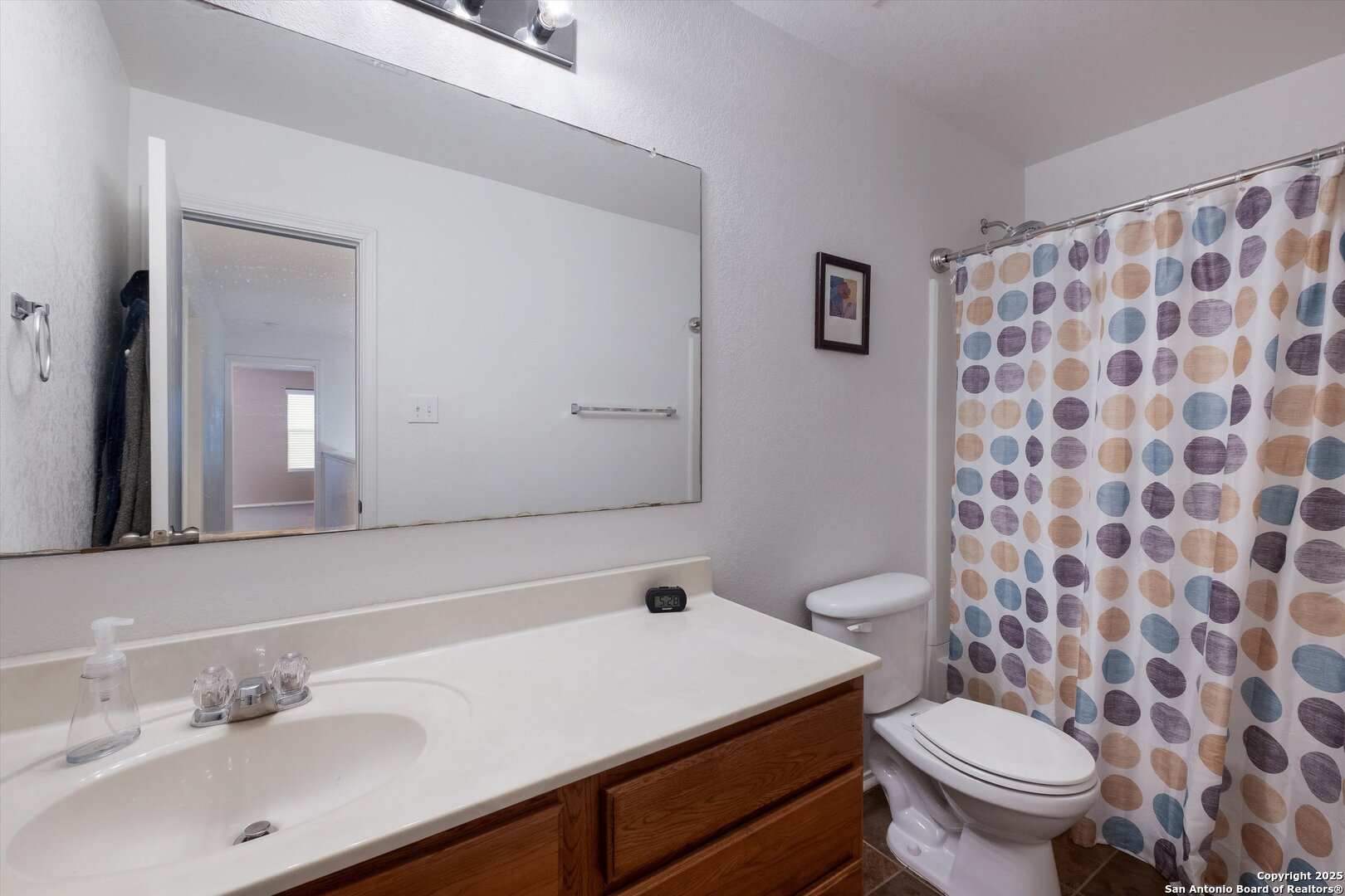 10711 Rindle Ranch San Antonio, TX 78249 - Photo 23 of 31 a bathroom with a sink toilet and a mirror