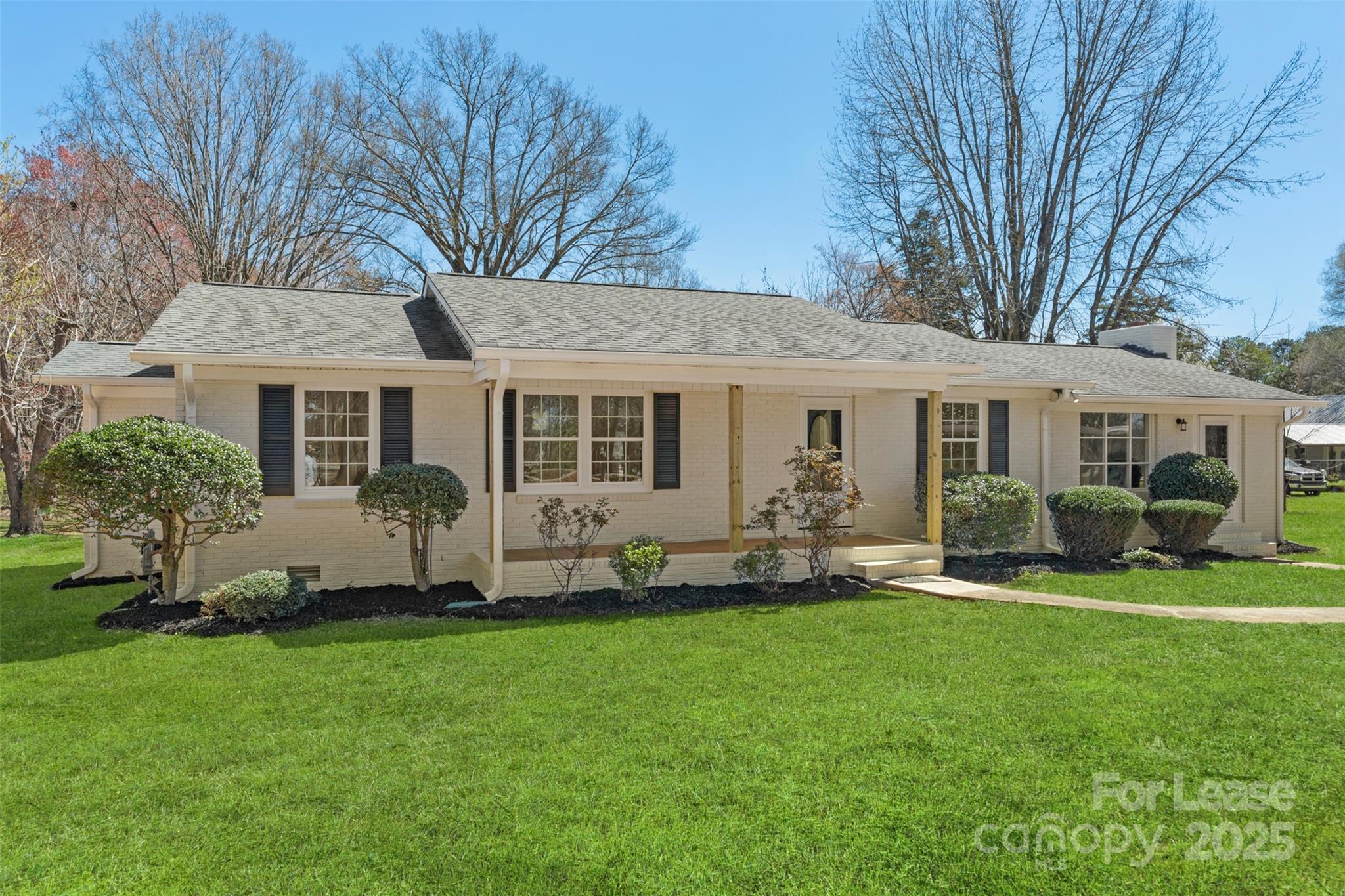 a front view of a house with a garden and yard