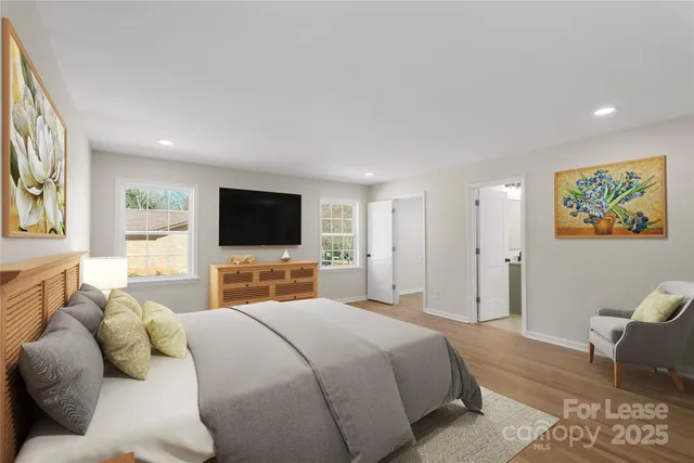 a bedroom with a bed a couch and a flat screen tv