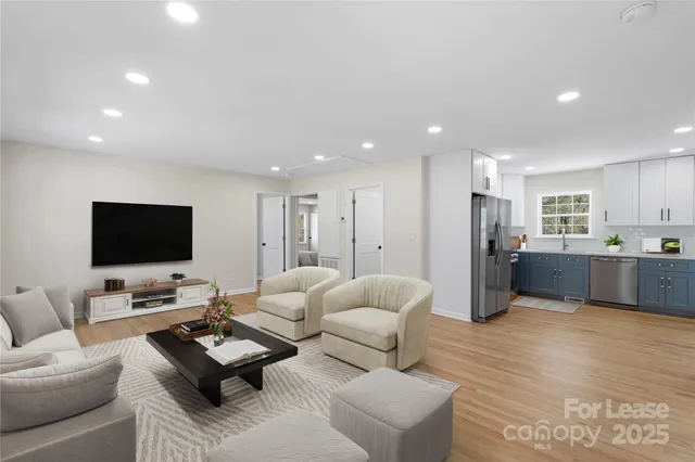 a living room with furniture flat screen tv and couches