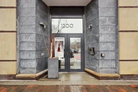 a front view of a building with street view and trees