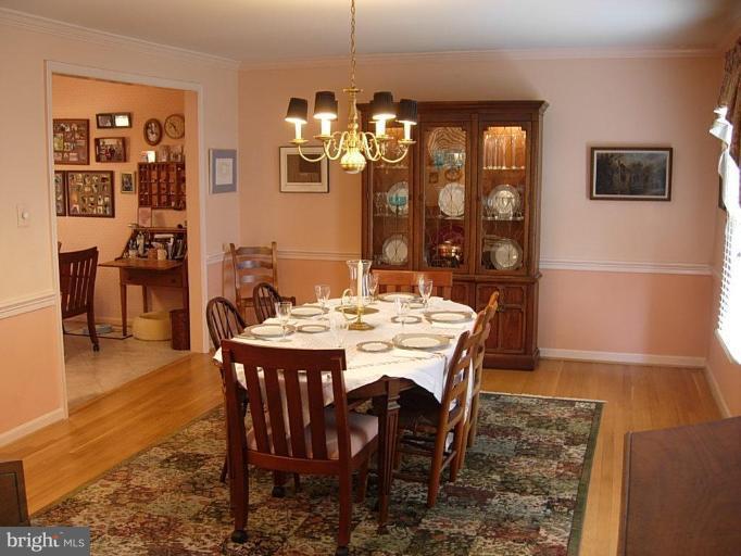15212 Redgate Drive Silver Spring, MD 20905 - Photo 3 of 28 a dining room with furniture a chandelier and wooden floor
