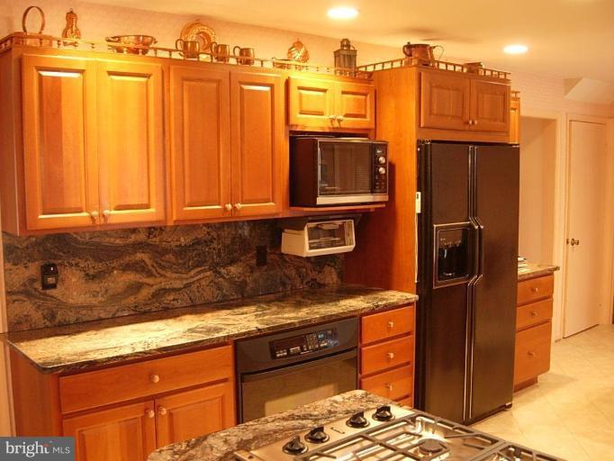 15212 Redgate Drive Silver Spring, MD 20905 - Photo 9 of 28 a kitchen with stainless steel appliances granite countertop a refrigerator and a stove top oven