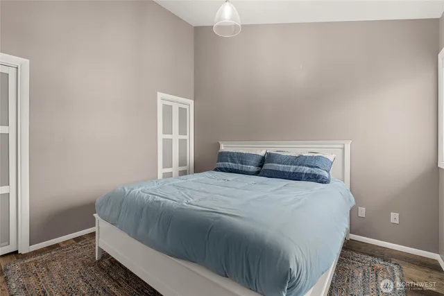 a bedroom with a bed and wooden floor