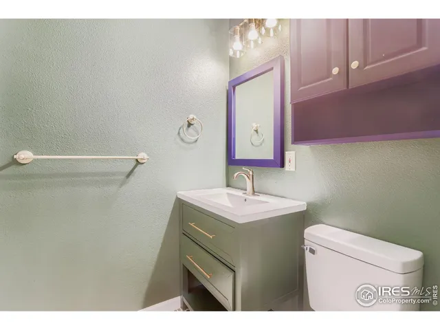 a bathroom with a sink mirror vanity and toilet