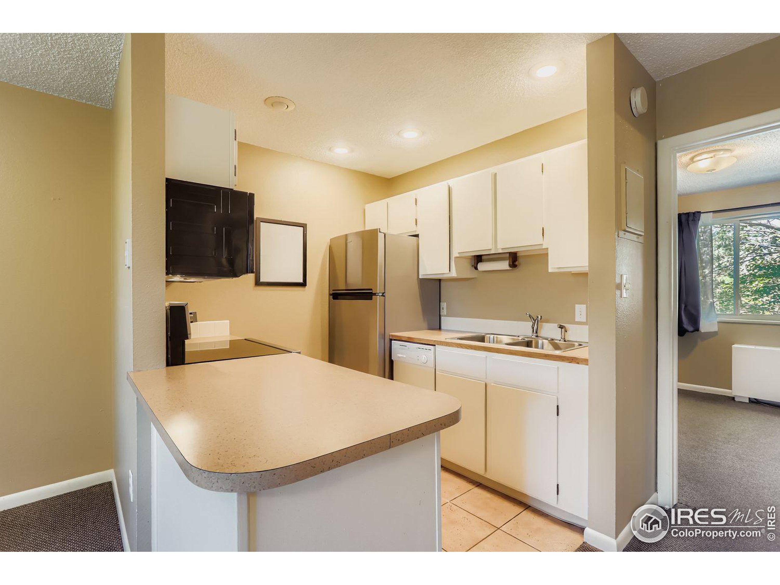 3000 Colorado Avenue, Unit B206 Boulder, CO 80303 - Photo 7 of 23 a kitchen with stainless steel appliances kitchen island granite countertop a refrigerator a sink a stove with white cabinets