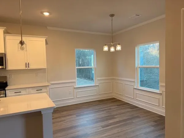 a kitchen with a sink a stove a refrigerator and white cabinets