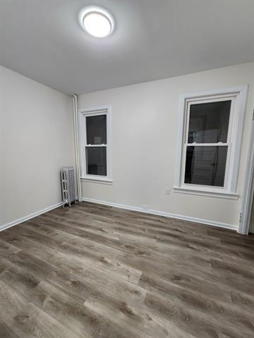 65 Halstead Street, Unit 1 Kearny, NJ 07032 - Photo 11 of 15 a view of an empty room with wooden floor and a window