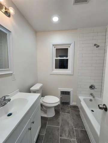 a bathroom with a bathtub shower sink mirror and toilet