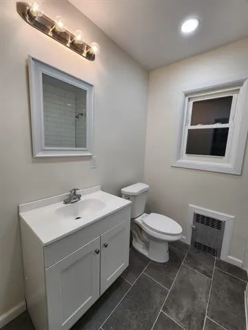 a bathroom with a toilet sink and mirror