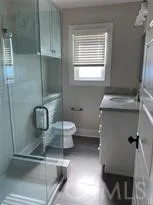 a bathroom with a granite countertop sink mirror and toilet