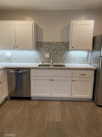 a kitchen with granite countertop white cabinets and stainless steel appliances