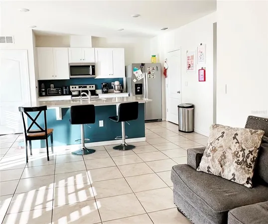 a kitchen with stainless steel appliances kitchen island granite countertop a refrigerator and a stove top oven