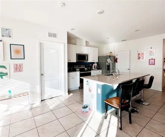 a living room with furniture a flat screen tv and kitchen view