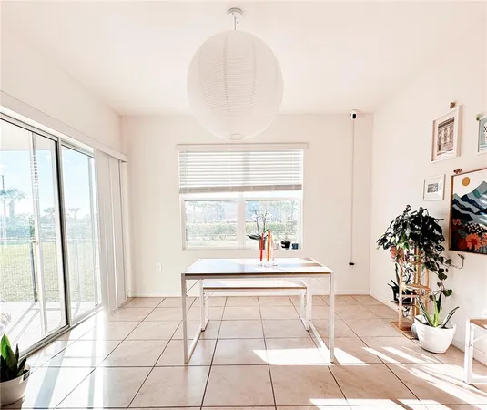 a dining room with chandelier fan and wooden floor