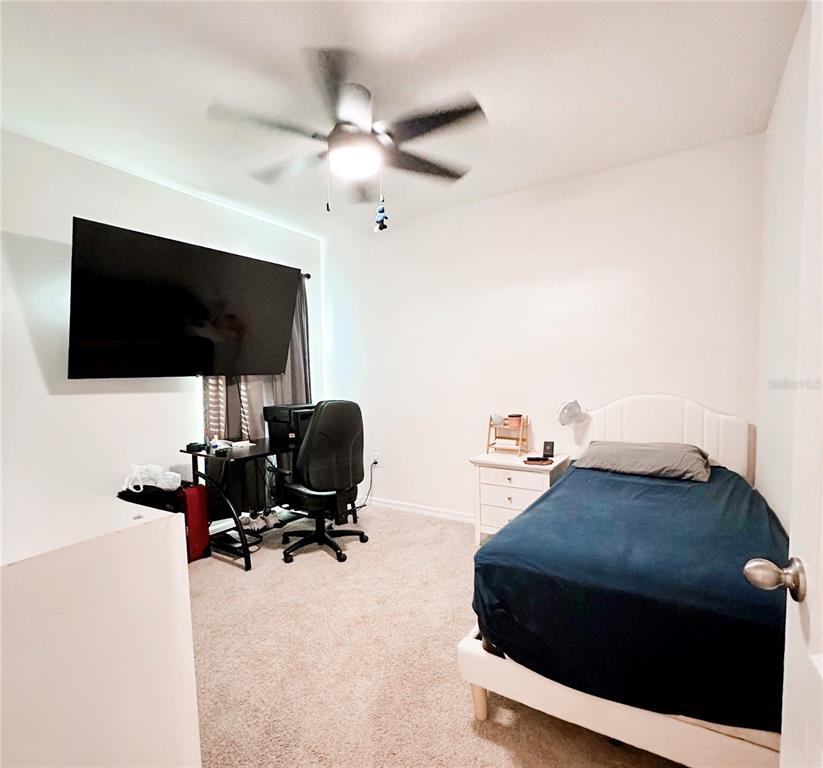 1122 Brimstone Circle Winter Haven, FL 33884 - Photo 10 of 17 a bedroom with a bed window and a flat screen tv