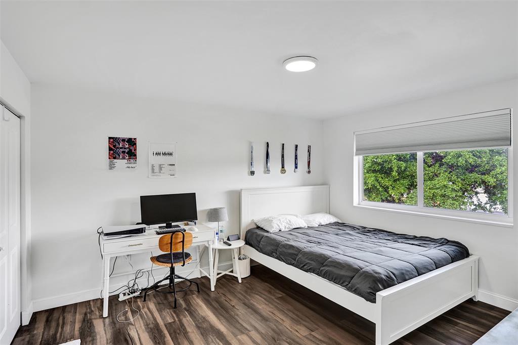 930 Greenbriar Avenue Davie, FL 33325 - Photo 11 of 28 a bedroom with a bed and a laptop on the desk