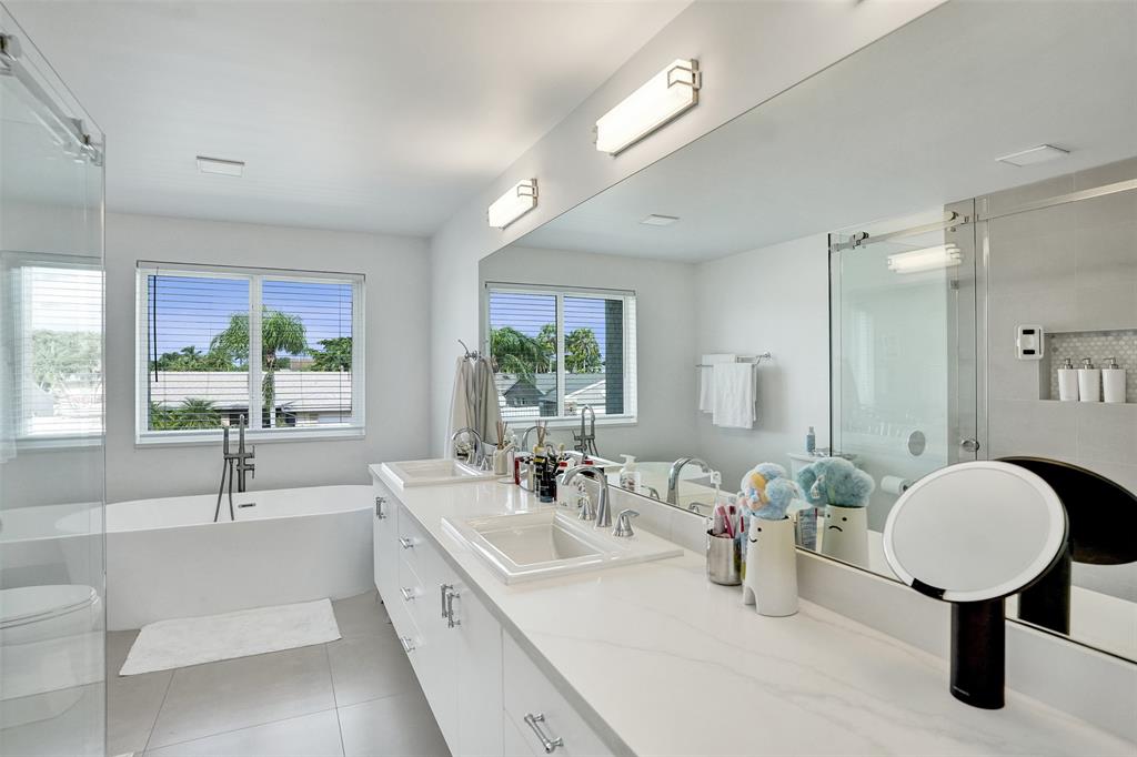 930 Greenbriar Avenue Davie, FL 33325 - Photo 12 of 28 a bathroom with a double vanity sink a mirror and a bathtub