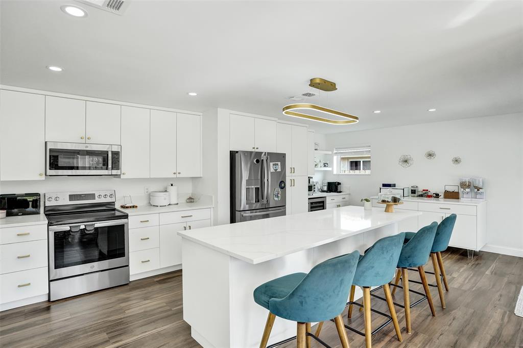 930 Greenbriar Avenue Davie, FL 33325 - Photo 20 of 28 a kitchen with stainless steel appliances a dining table chairs stove refrigerator and sink