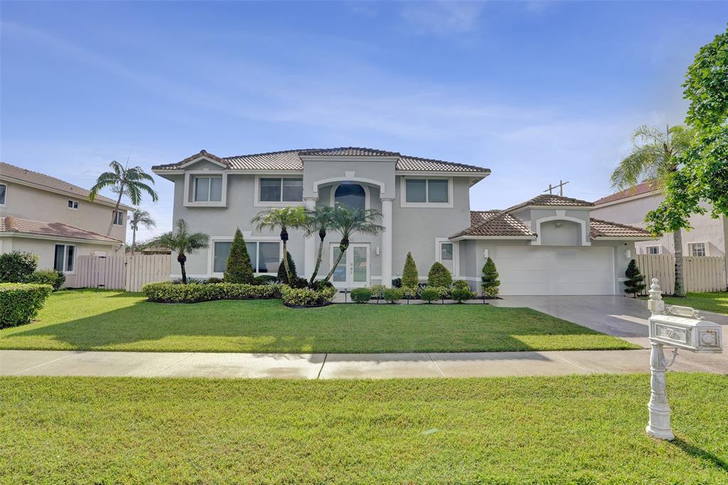 930 Greenbriar Avenue Davie, FL 33325 - Photo 2 of 28 a front view of a house with a yard and garage