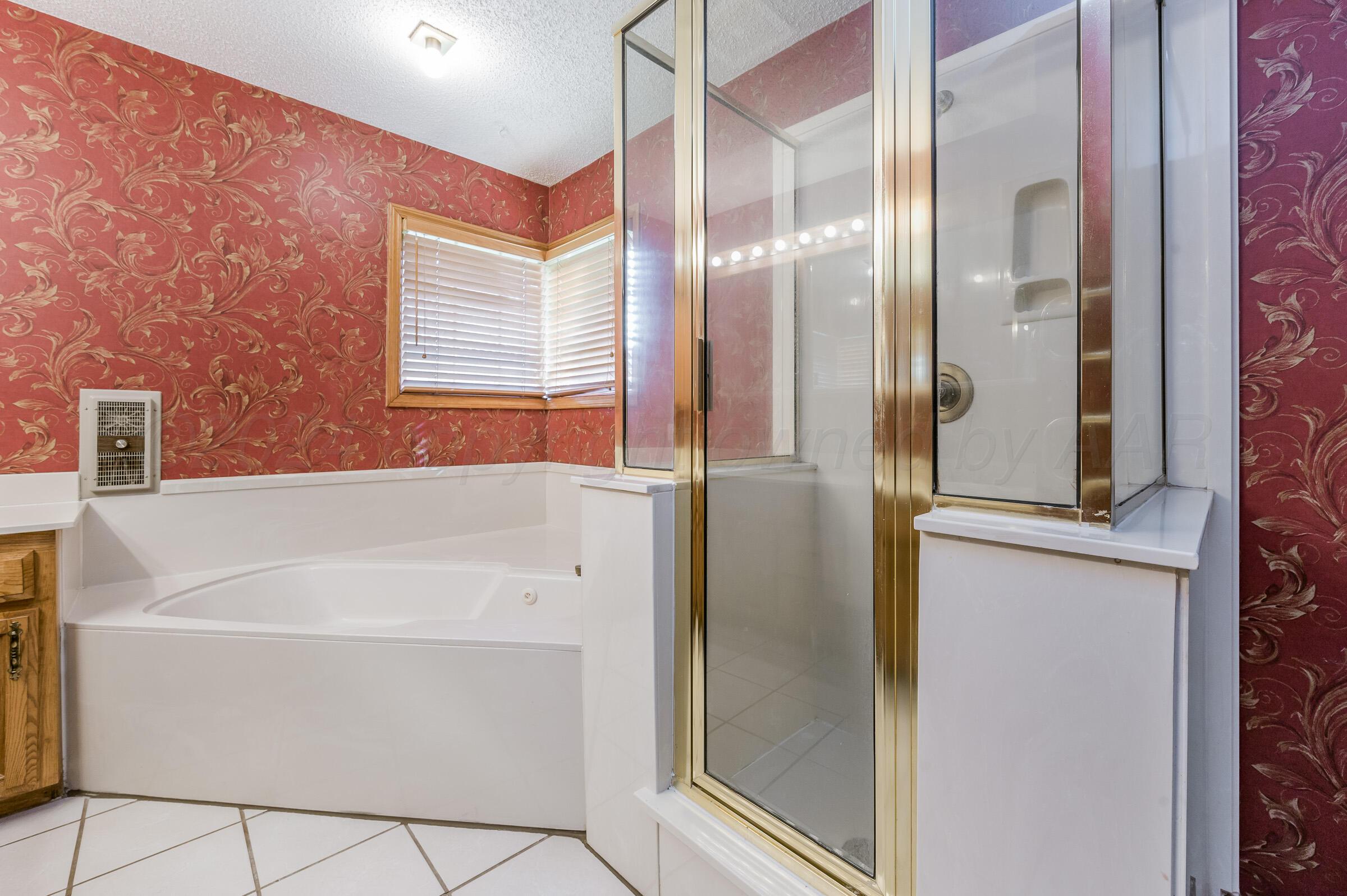 7212 Dukes Place Amarillo, TX 79109 - Photo 13 of 21 a bathroom with a bathtub and a shower