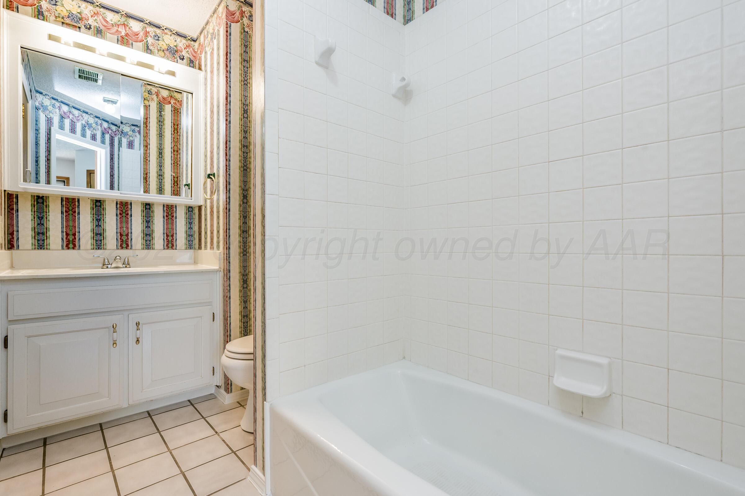 7212 Dukes Place Amarillo, TX 79109 - Photo 15 of 21 a bathroom with a bathtub and a shower