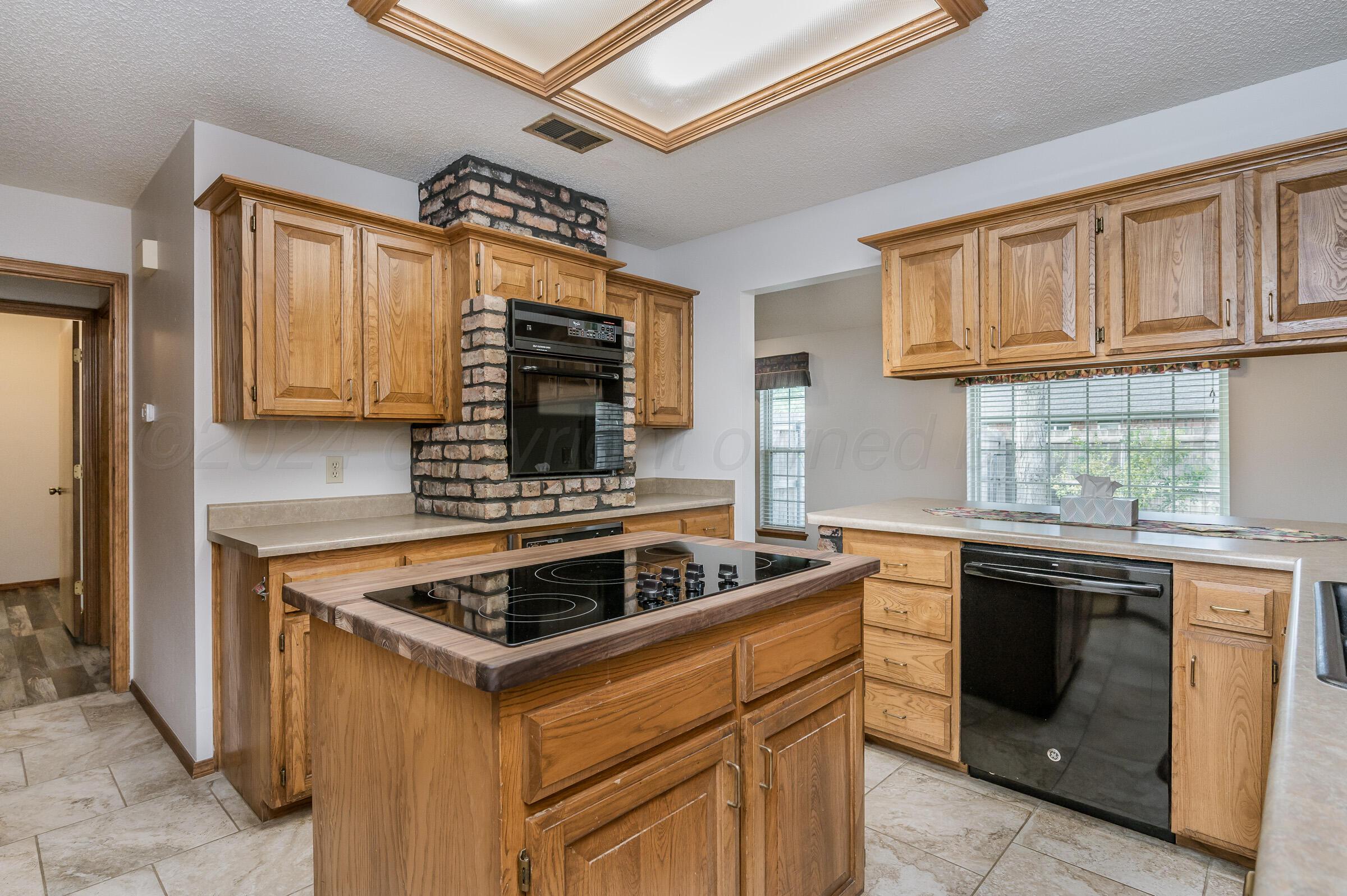 7212 Dukes Place Amarillo, TX 79109 - Photo 9 of 21 a kitchen with granite countertop a stove sink and cabinets
