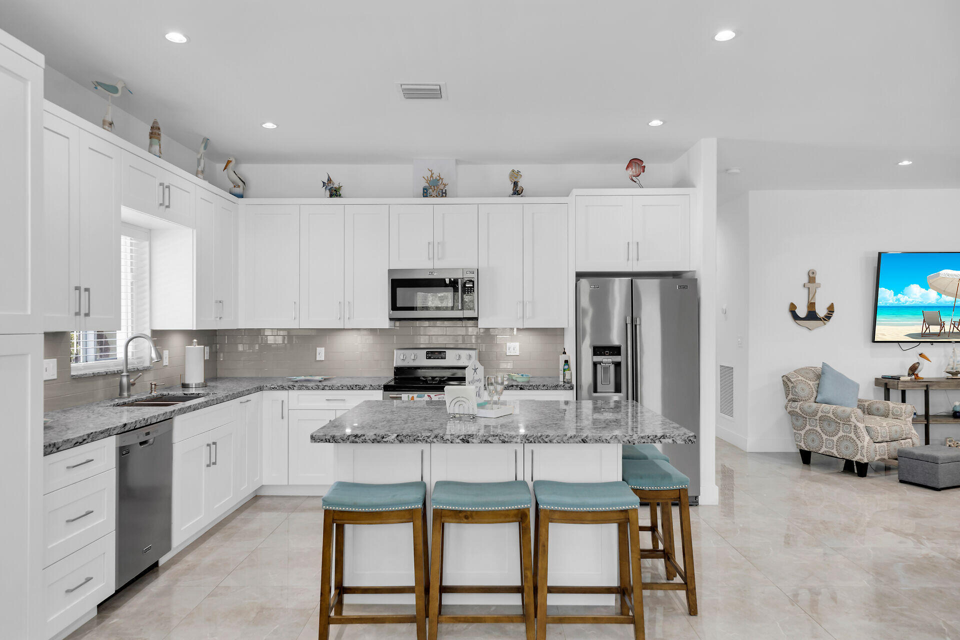667 Colson Drive Key Largo, FL 33037 - Photo 12 of 48 a kitchen with stainless steel appliances kitchen island granite countertop a table chairs sink and cabinets