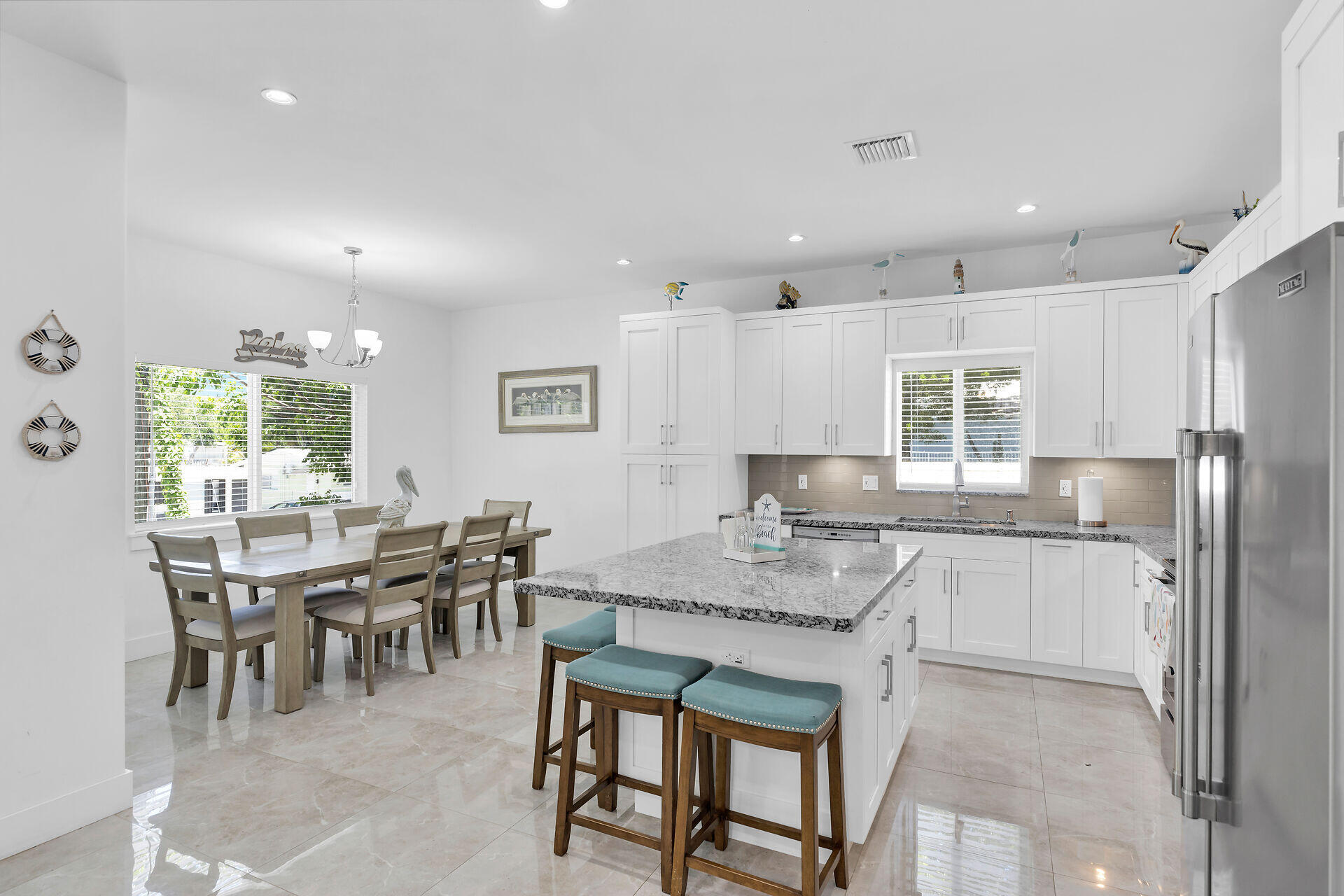 667 Colson Drive Key Largo, FL 33037 - Photo 9 of 48 a kitchen with stainless steel appliances granite countertop table chairs sink and cabinets