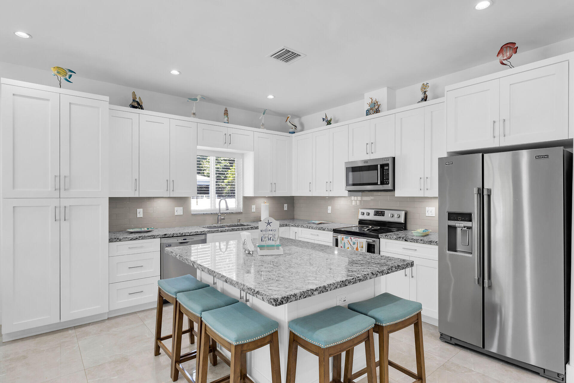 667 Colson Drive Key Largo, FL 33037 - Photo 10 of 48 a kitchen with granite countertop kitchen island cabinets and refrigerator
