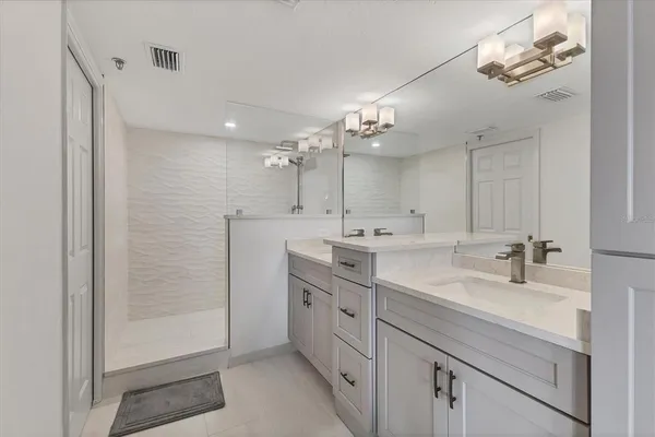 a bathroom with a double vanity sink a mirror and a shower