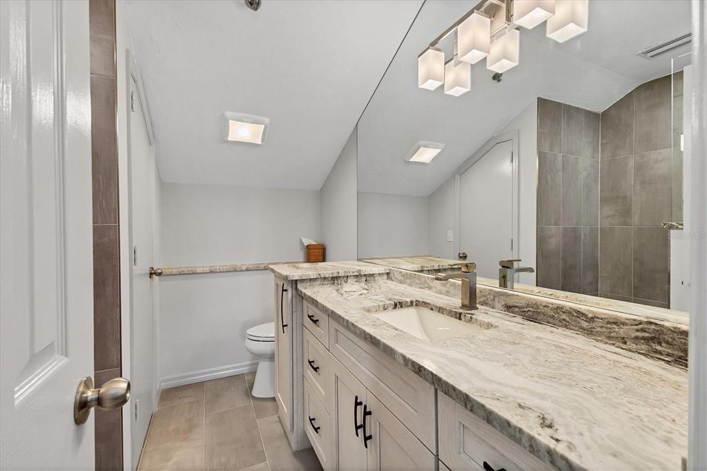 11000 Placida Road, Unit 1604 Placida, FL 33946 - Photo 27 of 42 a bathroom with a granite countertop sink a toilet and a mirror