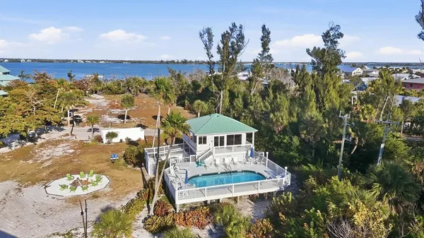 an aerial view of a house with a yard and lake view