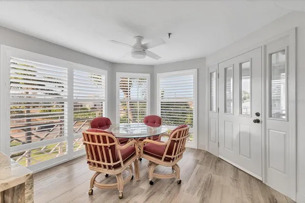 a dining room with furniture large windows and wooden floor