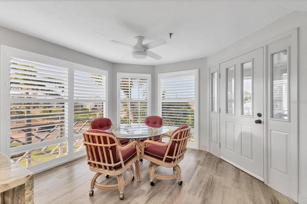 11000 Placida Road, Unit 1604 Placida, FL 33946 - Photo 5 of 42 a dining room with furniture large windows and wooden floor