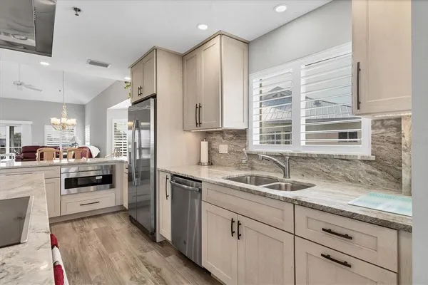 a kitchen with a sink cabinets stainless steel appliances and a window