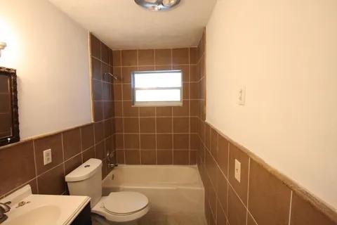 1050 East Sample Road, Unit 101 Pompano Beach, FL 33064 - Photo 12 of 19 a bathroom with a toilet a sink and bathtub