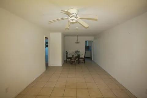 1050 East Sample Road, Unit 101 Pompano Beach, FL 33064 - Photo 15 of 19 a view of a dining room with furniture and a chandelier fan